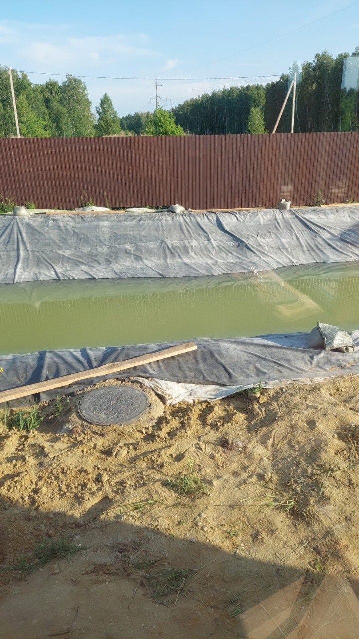 Гидроизоляция пруда — мембрана прижата по краям
